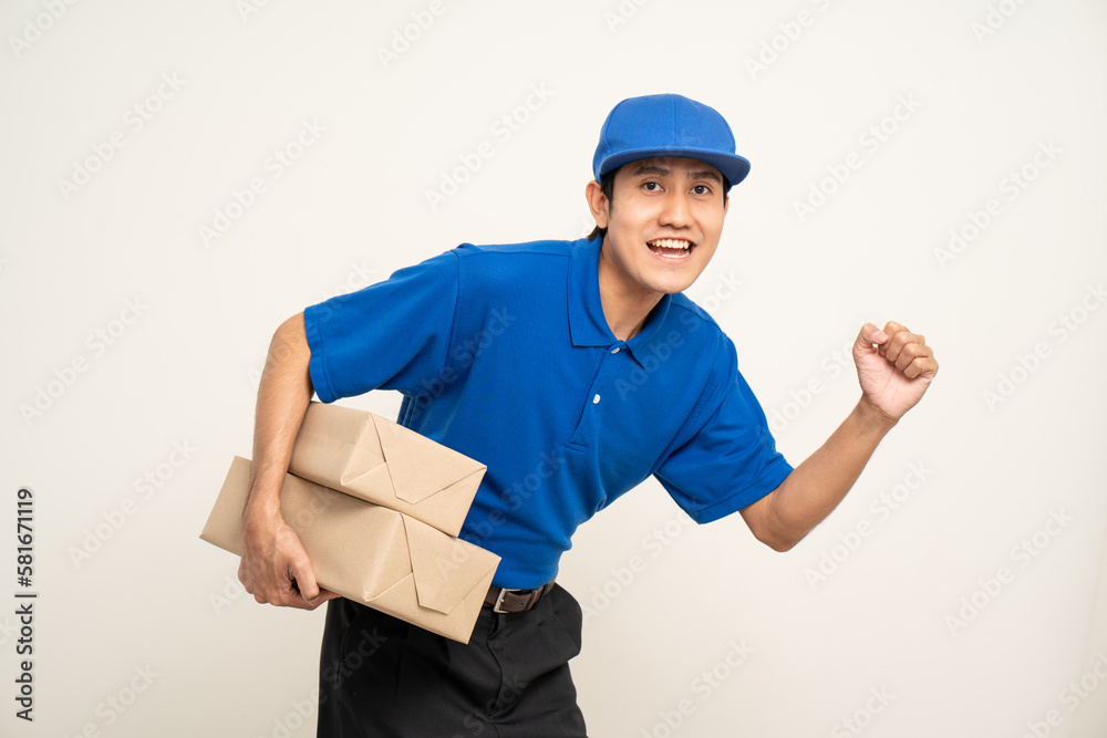 Asian man in blue uniform standing holding box parcel cardboard and smartphone on isolated white background. Male service worker with cell phone. Delivery courier shipping service Asian man in blue uniform standing holding box parcel cardboard and smartphone on isolated white background. Male service worker with cell phone. Delivery courier shipping service