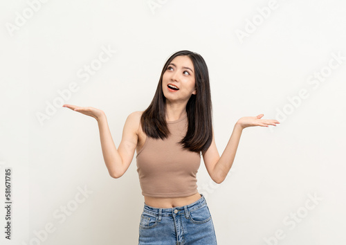 Beautiful smiling happy young asian woman in brown shirt. Charming female lady open hands palm up holding something on isolated white background. Asian cute Pretty people looking copy space.
