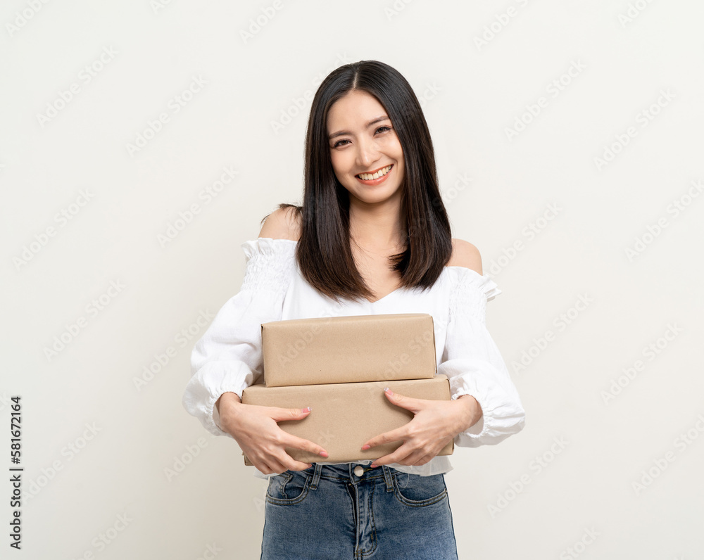 Young excited beautiful asian woman with parcel cardboard standing on isolated background. Cheerful female holding lot of parcel box receive from the delivery service shopping online application Young excited beautiful asian woman with parcel cardboard standing on isolated background. Cheerful female holding lot of parcel box receive from the delivery service shopping online application