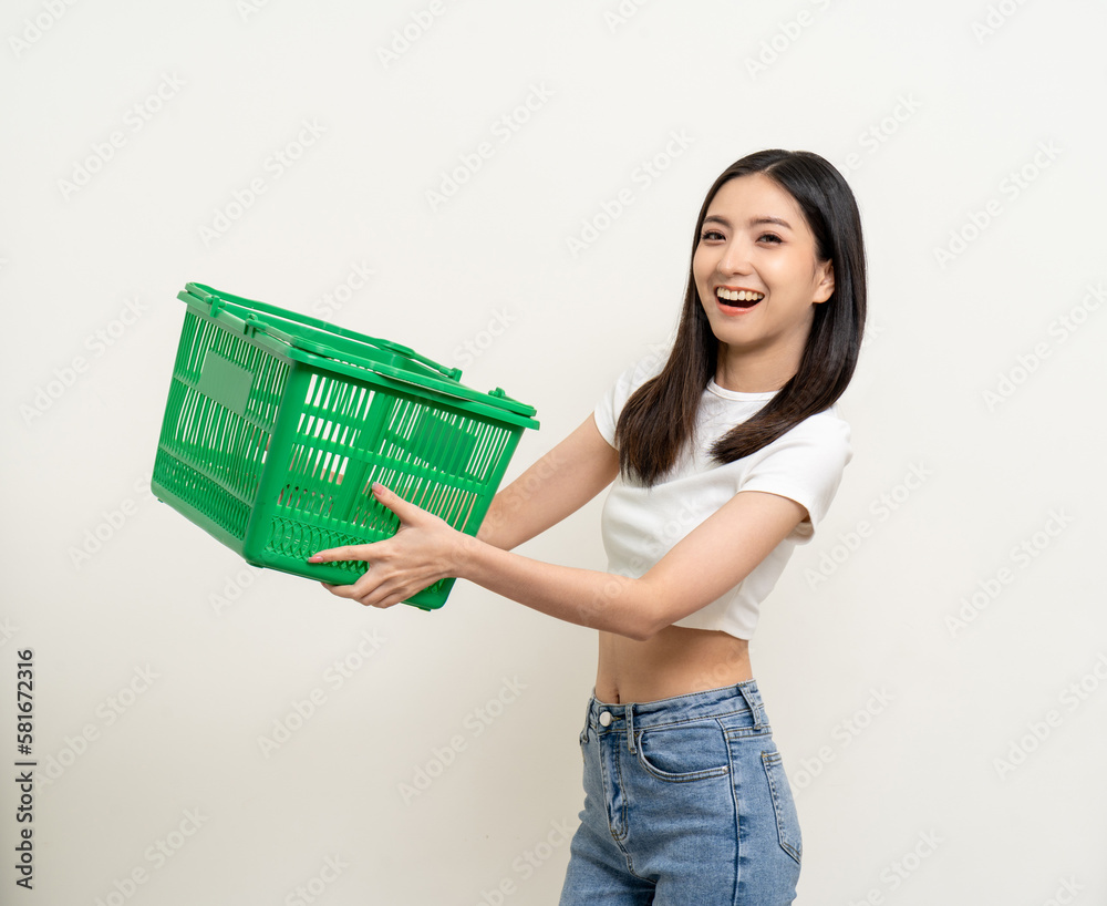 Happy beautiful woman holding shopping basket. Portrait beautiful asian female in fashion style standing pose on isolated background. Young asian woman shopping at online market application Happy beautiful woman holding shopping basket. Portrait beautiful asian female in fashion style standing pose on isolated background. Young asian woman shopping at online market application