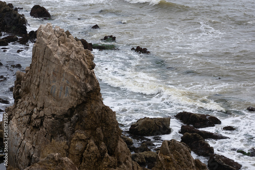 Rocks and cliffs with crashing waves on the coast of Southern California in Newport Beach