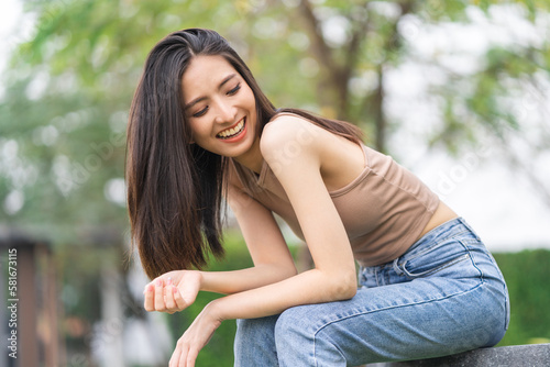 Happy feeling of Beautiful Young Woman smiling outdoor in sunlight. Pretty attractive face of female and beautiful smile. She is positive thinking and successful.