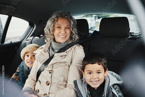 Portrait, car ride and grandmother relax with children or grandchildren while travel or on a road trip in the backseat. Bonding, happy and grandma traveling with kids or grandkids on a journey