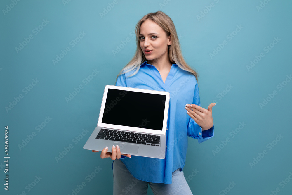 smiling blonde girl with a laptop in her hands with an empty space for a web page on a blue background smiling blonde girl with a laptop in her hands with an empty space for a web page on a blue background