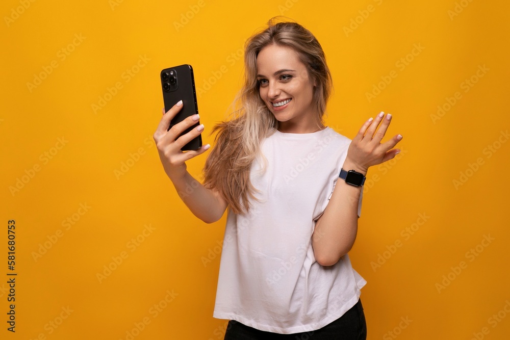 girl takes a selfie on the phone on a yellow background girl takes a selfie on the phone on a yellow background