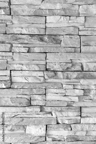 Modern and stylish black white gray and grey colored brick pattern textures are regularly listed and stacked with a pile of stone material background