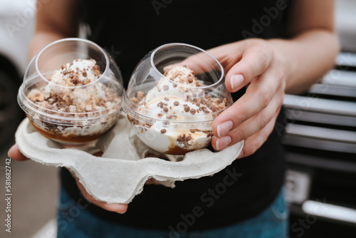 Closeup of female hands holding chocolate ice-creams desserts. Instagram look filter. 