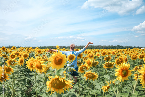 Woman in the sunflowers field. Summer time. Young beautiful woman standing in sunflower field. 