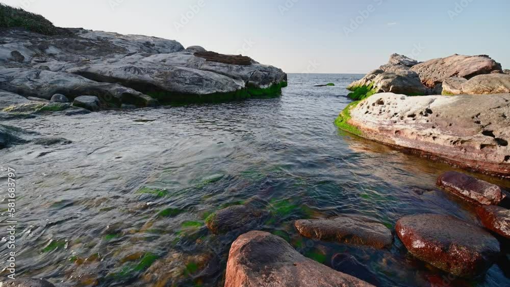 Calm and clear waters flow into small coves. Some green algae grow on rocks. The peculiar rocky landscape of Ruifang Nanya, New Taipei City. Taiwan Calm and clear waters flow into small coves. Some green algae grow on rocks. The peculiar rocky landscape of Ruifang Nanya, New Taipei City. Taiwan