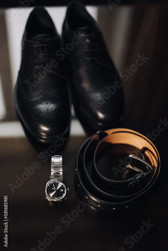 man 's shoes and a man's accessories on a wooden background