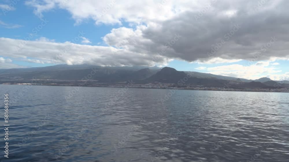 Tenerife Island As Seen From A Feribot In The Summer With Blue Sky And Thick White Clouds, Spain Tenerife Island As Seen From A Feribot In The Summer With Blue Sky And Thick White Clouds, Spain