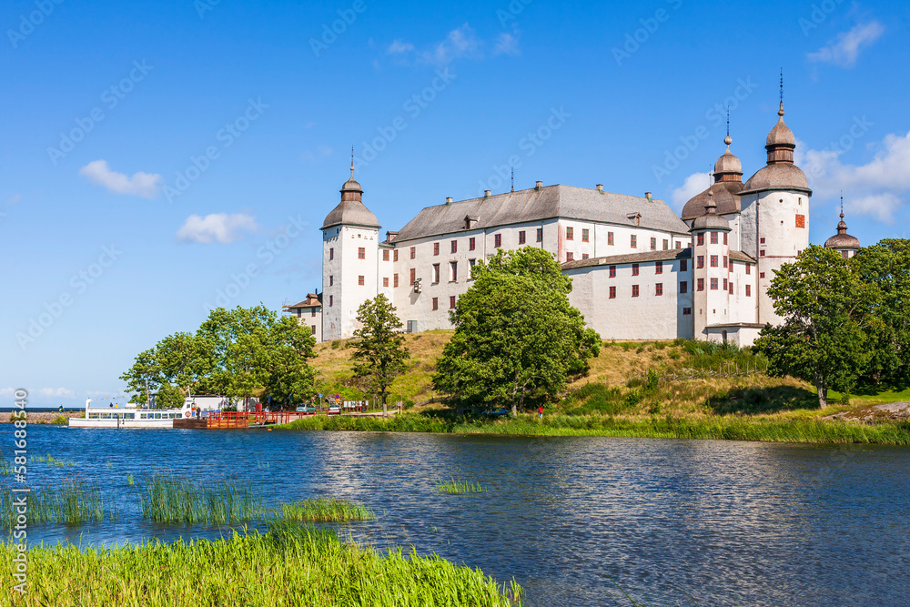 Lacko castle by the lake Vanern in Sweden with tourist boat at the pier