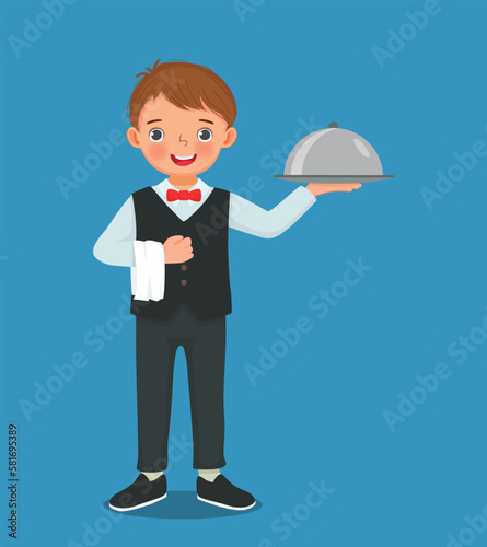 Cute little boy waiter holding silver tray serving food