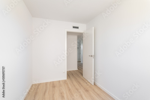 Empty white unfurnished room with wooden laminate flooring  ventilation and access to another room. Concept of studio or mini hotel. Copyspace