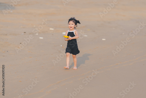 very happy time of cute girl in dress black run play on the beach with blur background beautiful sunset light in the sea