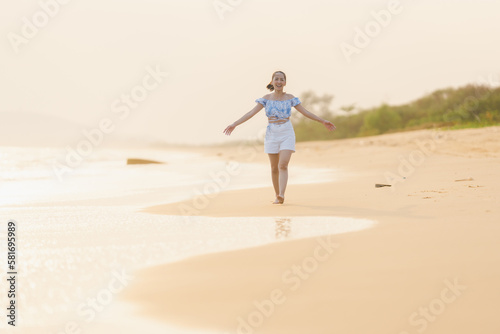 happy time of woman walking and run play on the beach with blur background beautiful sunset light in the sea