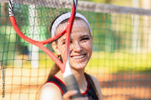 Fototapeta Naklejka Na Ścianę i Meble -  Professional girl athlete playing tennis on court. female player with racket, ball near net outdoor. healthy sport active lifestyle. lady with ceramic braces to align bite teeth