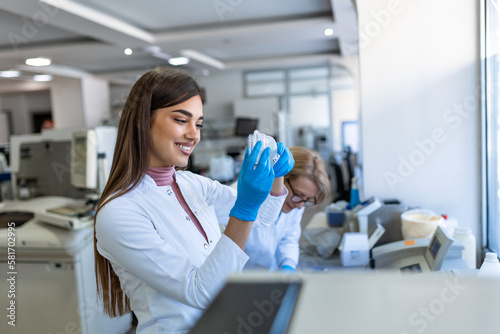 Female Medical Research Scientist Looks at Biological Samples Before Analysing it Under Digital Microscope in Applied Science Laboratory. Lab Engineer in White Coat Working on Vaccine and Medicine