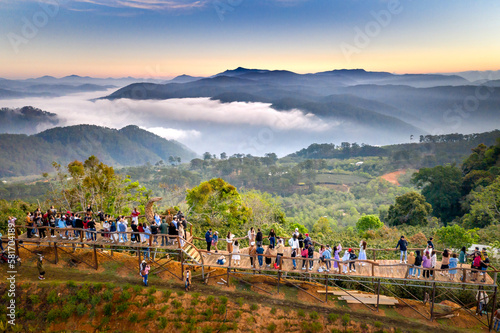 A group of young people watching the sunrise on top of a tea hill in Cau Dat, Da Lat town, Lam Dong province, Vietnam
