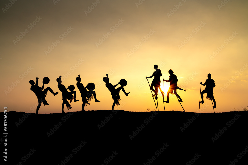 Silhouettes of Ede boys and girls performing their traditional dance during sunset in Pleiku town, Gia Lai province, Vietnam.