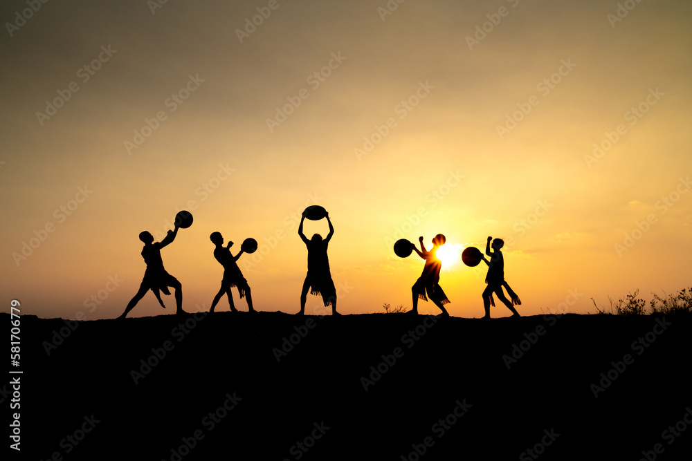 Silhouettes of Ede boys and girls performing their traditional dance during sunset in Pleiku town, Gia Lai province, Vietnam. Silhouettes of Ede boys and girls performing their traditional dance during sunset in Pleiku town, Gia Lai province, Vietnam.