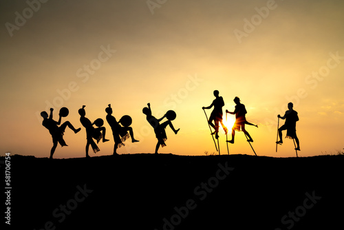 Silhouettes of Ede boys and girls performing their traditional dance during sunset in Pleiku town, Gia Lai province, Vietnam.