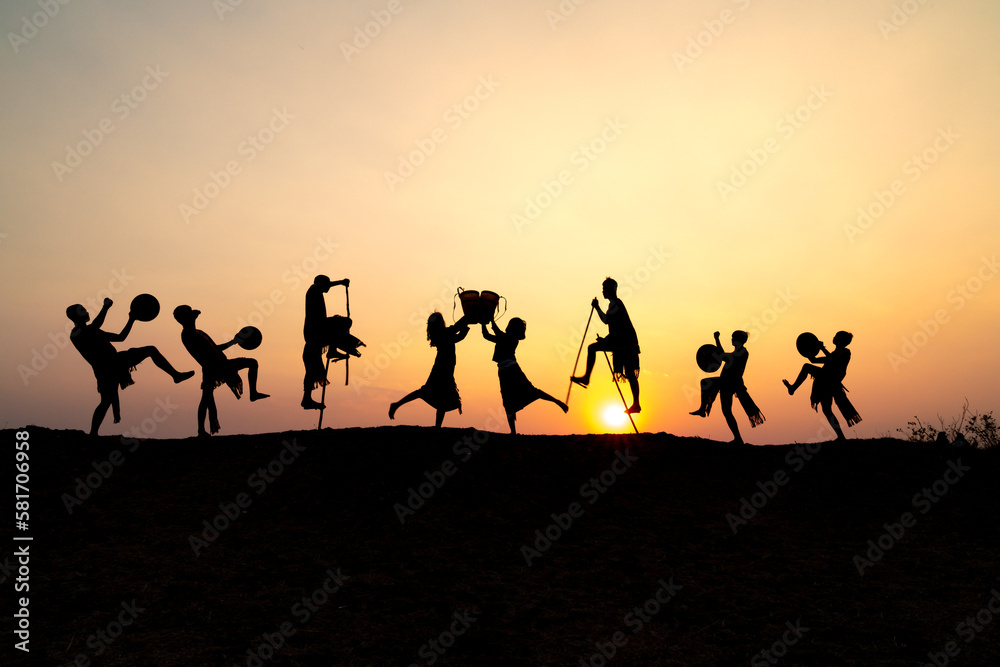 Silhouettes of Ede boys and girls performing their traditional dance during sunset in Pleiku town, Gia Lai province, Vietnam. Silhouettes of Ede boys and girls performing their traditional dance during sunset in Pleiku town, Gia Lai province, Vietnam.