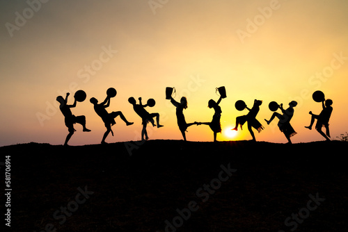 Silhouettes of Ede boys and girls performing their traditional dance during sunset in Pleiku town  Gia Lai province  Vietnam.