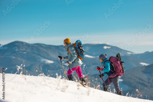 Tourists travel together in the mountains in winter. two girls snow-capped mountains.