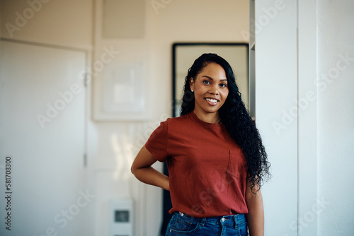 Young happy black woman at home looking at camera.