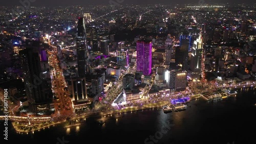Wallpaper Mural Ho Chi Minh City, Vietnam iconic Skyline and Saigon river waterfront aerial on a busy night featuring all key buildings illuminated with colored lights Torontodigital.ca