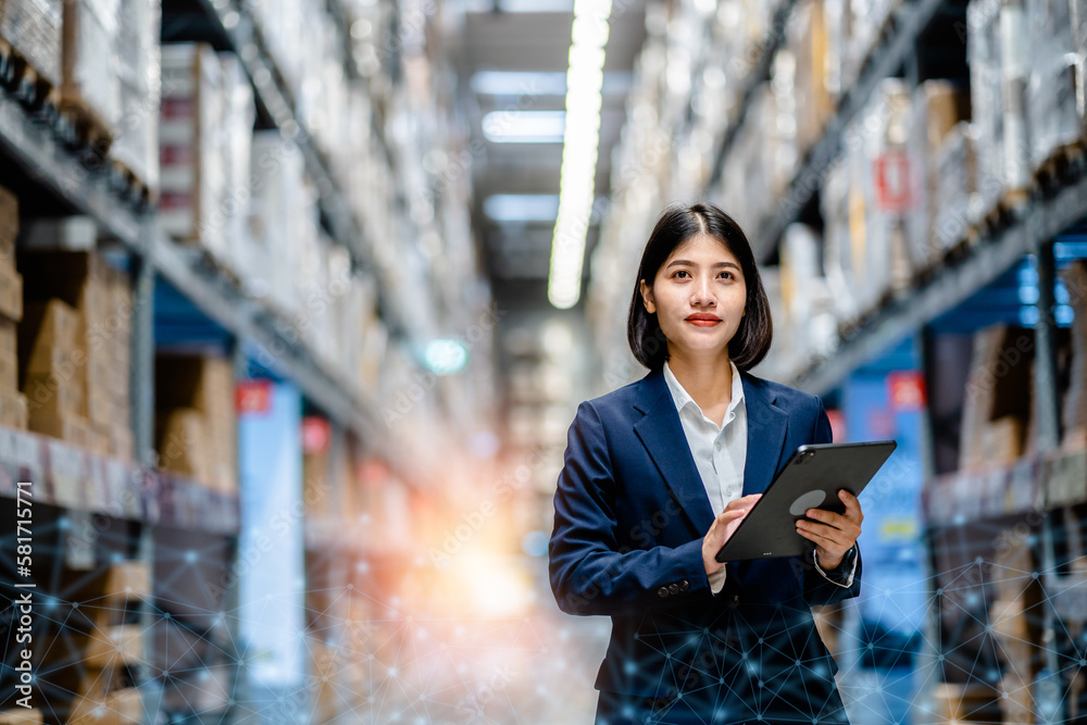 Business women use a digital tablet to manage the stock inventory on shelves in the large warehouse, smart cargo management system, supply chain and logistic network technology concept. Business women use a digital tablet to manage the stock inventory on shelves in the large warehouse, smart cargo management system, supply chain and logistic network technology concept.