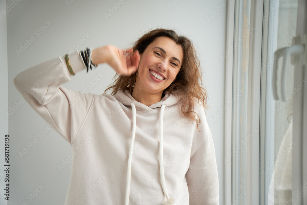 Portrait of happy smiling female relaxing at home looking straight into the camera. Attractive brunette caucasian girl with curly hair. Portrait of happy smiling female relaxing at home looking straight into the camera. Attractive brunette caucasian girl with curly hair.