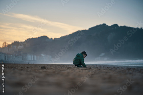 Niño en la playa en la hora azul 