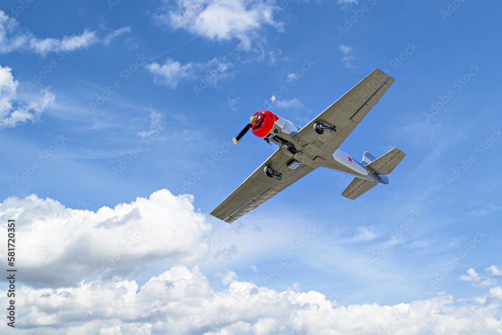 View of an acrobatic plane (aerodyne), in flight under a blue sky with white clouds. flight displays View of an acrobatic plane (aerodyne), in flight under a blue sky with white clouds. flight displays