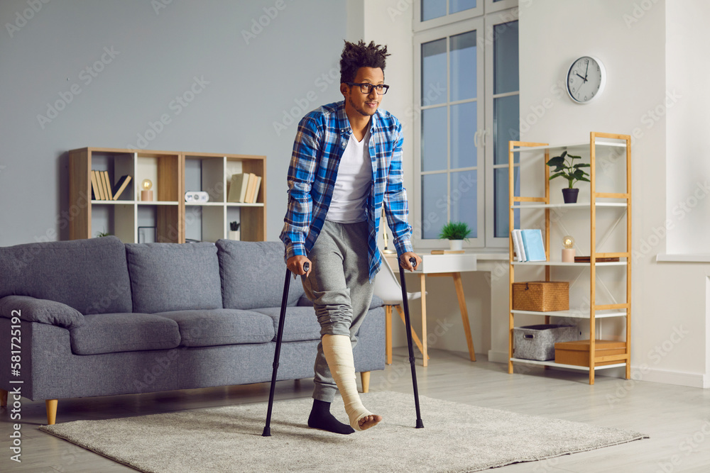Handicapped young african american man with broken leg trying to walk