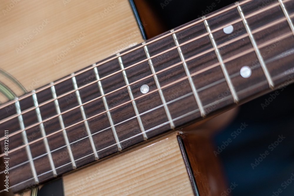 male hands playing acoustic guitar, close up.Acoustic guitar with a beautiful wood . male hands playing acoustic guitar, close up.Acoustic guitar with a beautiful wood .