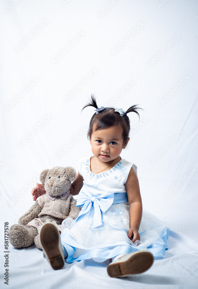 Little girl playing with her teddy beat isolated on white background. Little girl playing with her teddy beat isolated on white background.