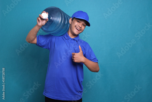Deliveryman in blue uniform carrying a water gallon and showing a thumb up