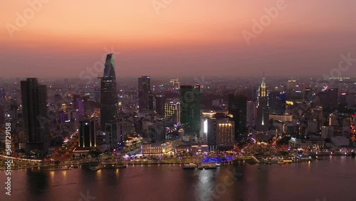 Wallpaper Mural Ho Chi Minh City, Vietnam iconic Skyline and Saigon river waterfront aerial panorama on a busy evening featuring all key buildings illuminated against beautiful colored sky. Slow aerial  tracking shot Torontodigital.ca