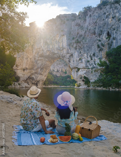 couple having picnic on the beach on vacation in the Ardeche France Pont d Arc, Ardeche France, view of Natural arch in Vallon Pont d'Arc in Ardeche canyon in France Europe Rhone Alps Dordogne photo