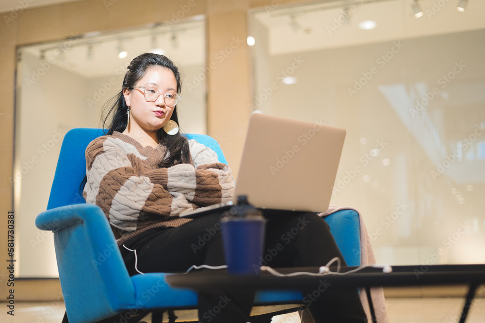 Young Asian girl working angry in a rest area of a shopping mall. Concept of teleworking. Young Asian girl working angry in a rest area of a shopping mall. Concept of teleworking.