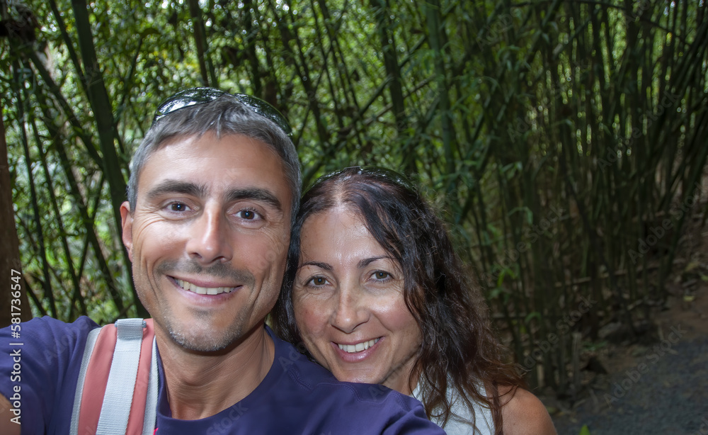 Selfie of a happy caucasian couple on vacation visiting tropical forest Selfie of a happy caucasian couple on vacation visiting tropical forest