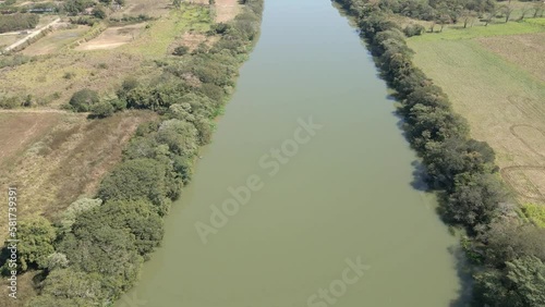 riparian forest of a large green river with pasture deforestation on the side with aerial view photo