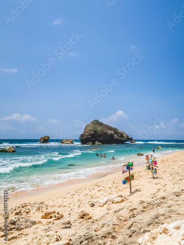 Tropical rocky beach with white sand and cliffs and blue sky with clouds on Sunny day. Summer tropical landscape, panoramic view. travel tourism wide panorama background concept.  © Rizky