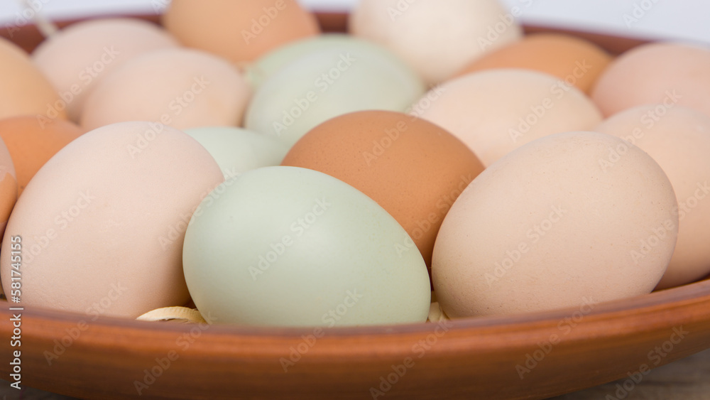 chicken eggs of different colors in a clay plate chicken eggs of different colors in a clay plate