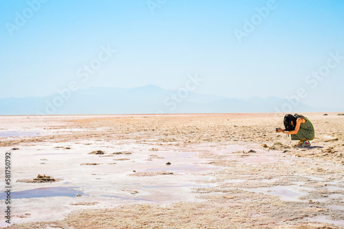 Caucasian woman blogger tourist capture Maharlu pink salt lake structures on holidays. Travel destination Iran in Shiraz