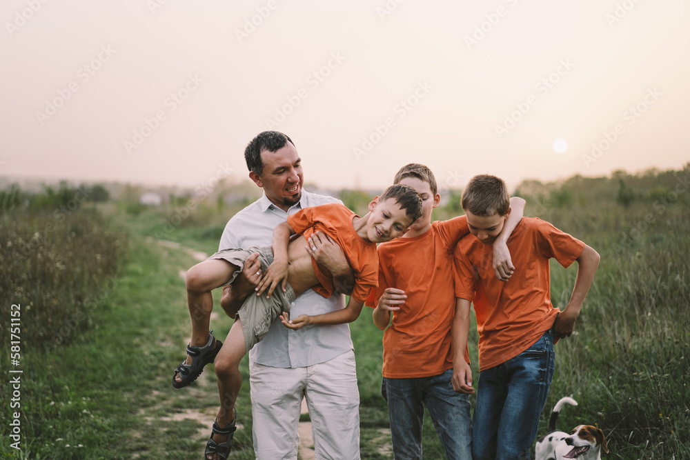 Happy Fathers day. Father with son are walking in the field. Dad hugs boy. The concept of Fathers day, relationships with children, care and love.