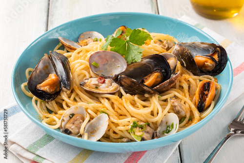 Piatto di deliziosi spaghetti conditi con cozze, vongole e bottarga, cibo italiano  photo