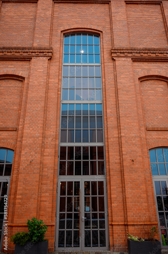 Obraz premium large window in a brick building Modern urban architecture; reconstruction of buildings of the old factory complex; brick walls and large windows of company offices; former workshops